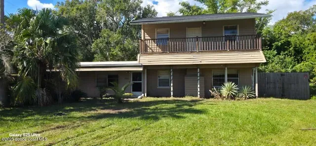 a view of a house with yard and sitting area