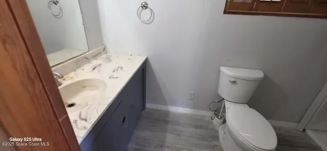 a bathroom with a granite countertop toilet and sink