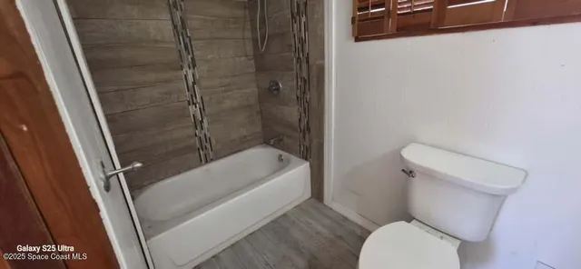 a white toilet sitting next to a bath tub
