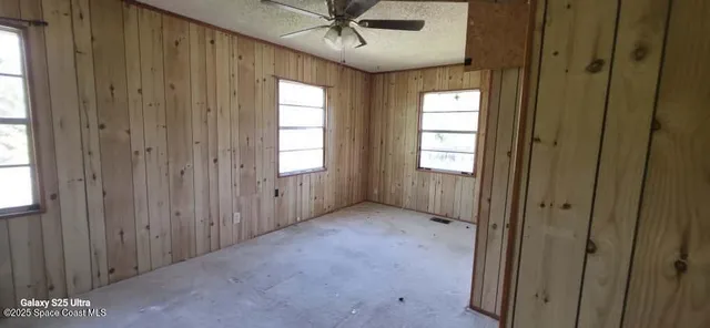 an empty room with windows and cabinet