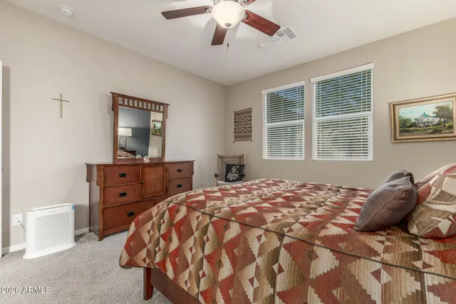 a bed sitting in a bedroom and a dresser next to a window