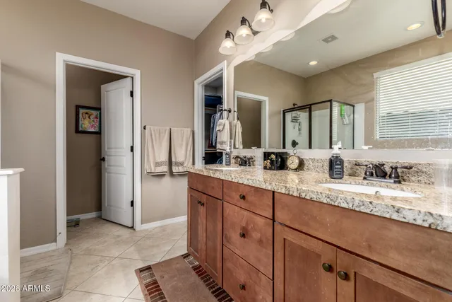a spacious bathroom with a granite countertop sink mirror and cabinets