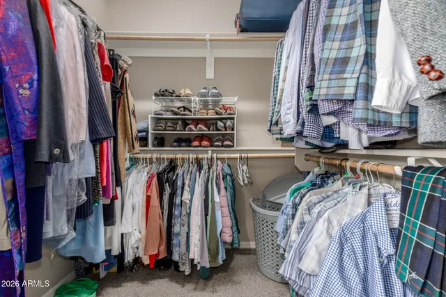 a view of walk in closet with clothes and shoes