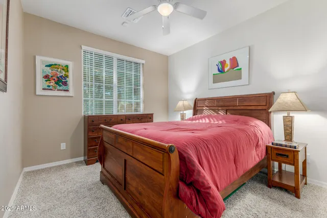 a bedroom with a bed and a painting on the wall