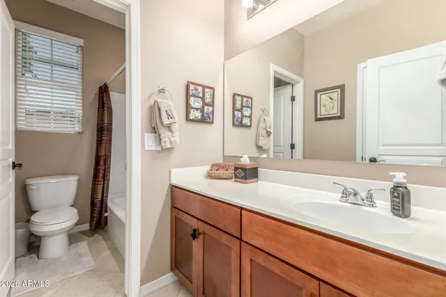 a bathroom with a granite countertop sink mirror vanity and toilet