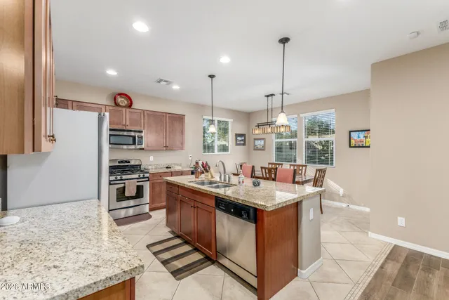 a kitchen with stainless steel appliances granite countertop sink stove and refrigerator