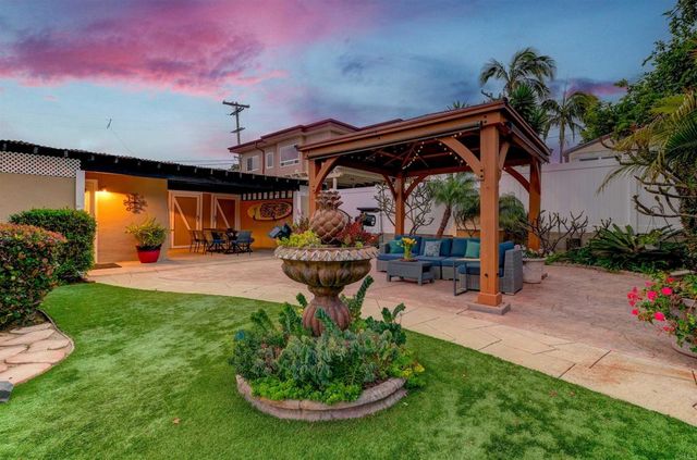 a view of a porch with a table and chairs under an umbrella
