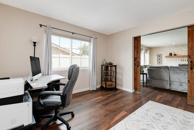 a view of a workspace with furniture and a window