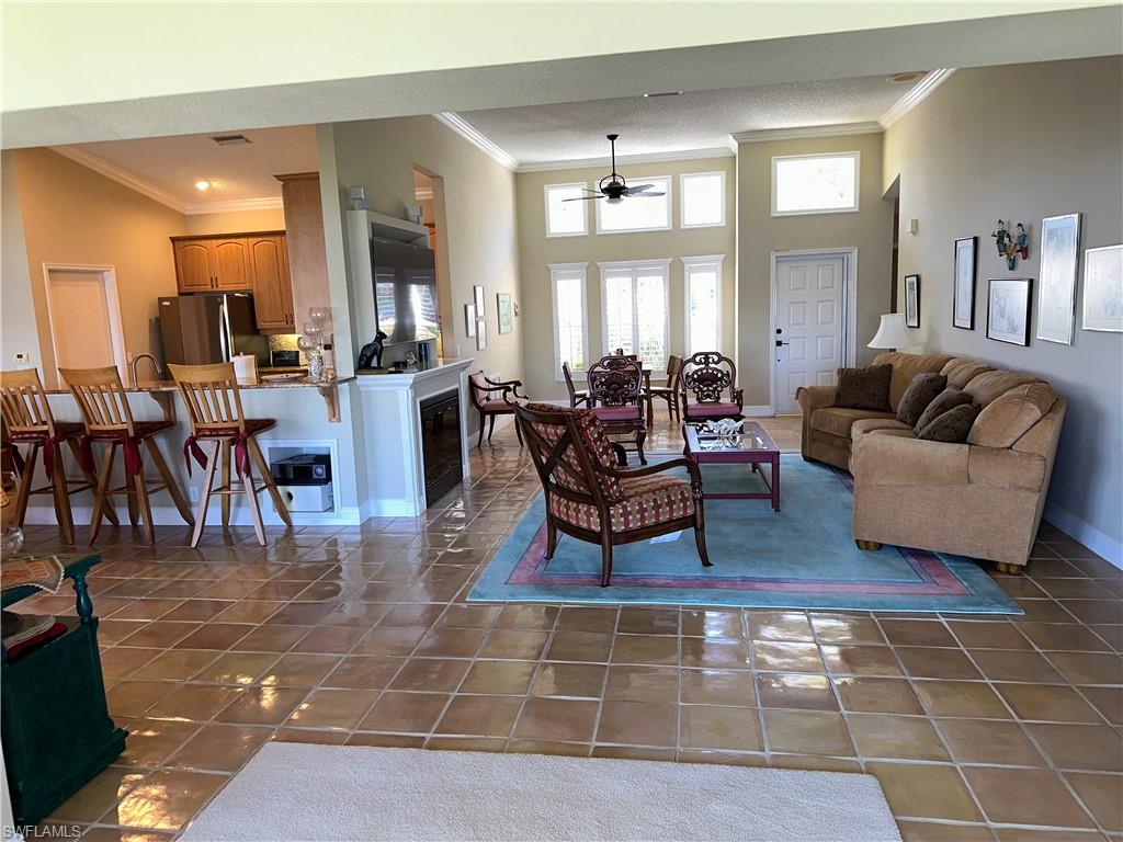 7159 Mill Pond Circle Naples, FL 34109 - Photo 17 of 27 a living room with couches a dining table and chairs with kitchen view