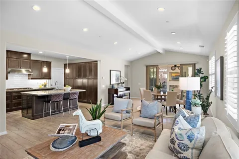a living room with furniture kitchen view and a large window