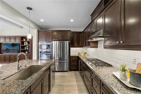 a kitchen with stainless steel appliances granite countertop a sink stove and refrigerator