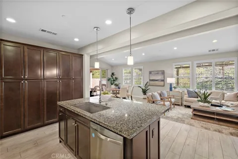 a kitchen with stainless steel appliances granite countertop a sink refrigerator and wooden floor
