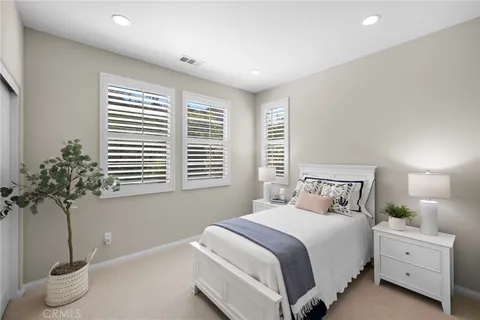 a bedroom with a bed and a potted plant