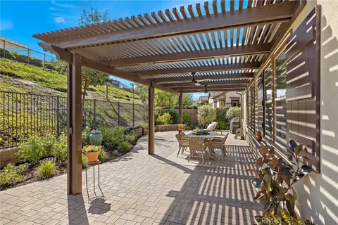 a view of a patio with table and chairs potted plants with floor to ceiling window