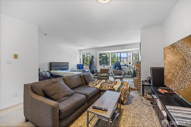 a living room with furniture a fireplace and a floor to ceiling window