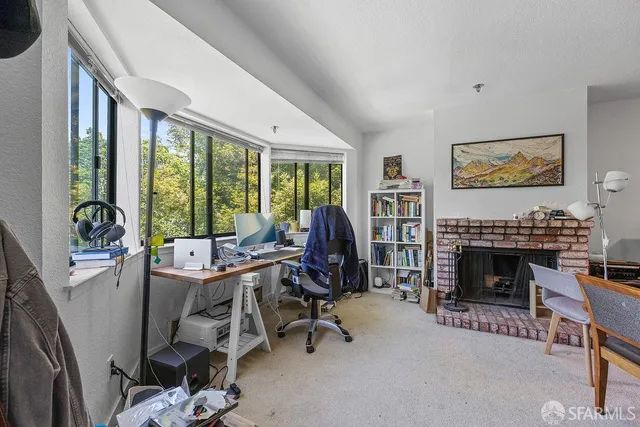 a living room with furniture a fireplace and a floor to ceiling window