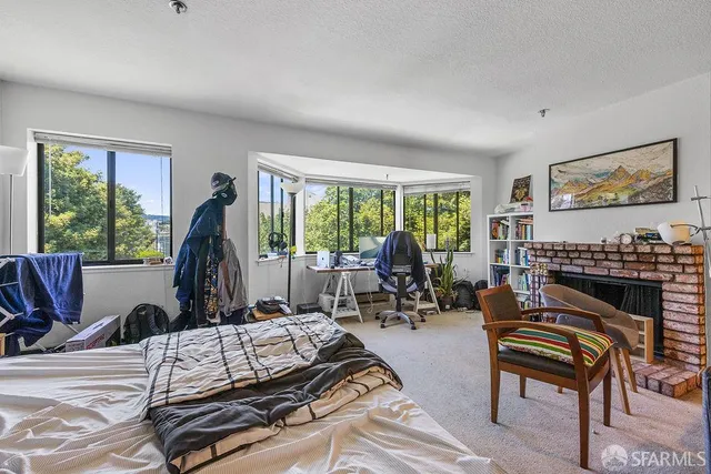 a spacious bedroom with a bed a table and chair