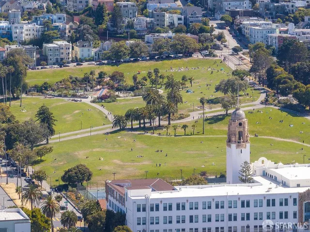 an aerial view of a residential houses with outdoor space and trees
