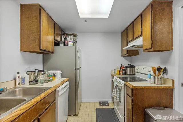 a kitchen with stainless steel appliances granite countertop a refrigerator a stove a sink and a microwave