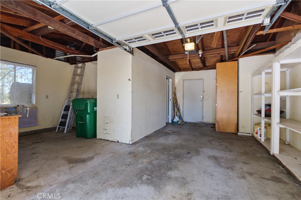 34881 Los Nogales Road Temecula, CA 92592 - Photo 40 of 50 Garage is currently a 1 car garage. Area with a workbench and cabinetry. There is also a built-in pantry with pull out drawers, built-in shelving. Door to the additional room and also the outdoor patio.
