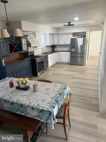 a kitchen with stainless steel appliances wooden cabinets and wooden floor