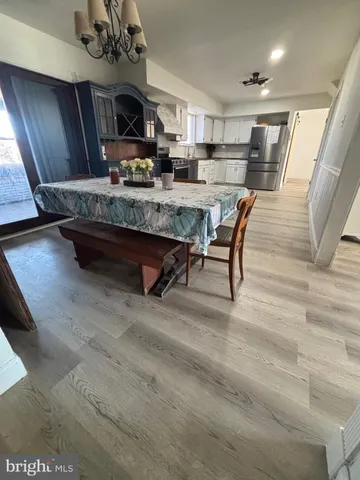 a living room with stainless steel appliances furniture a rug and kitchen view