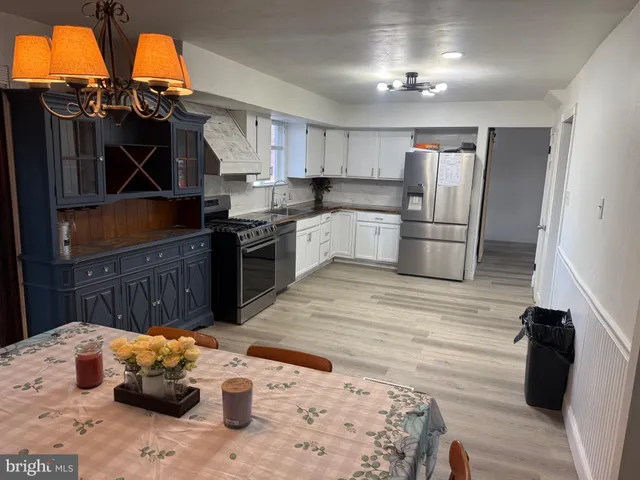a kitchen with stainless steel appliances kitchen island granite countertop a sink cabinets and wooden floor