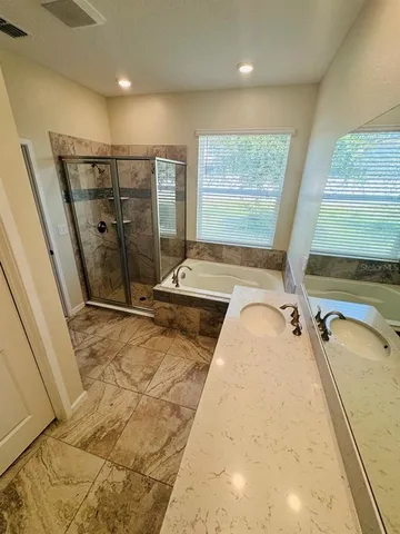 a bathroom with a tub a sink and a shower