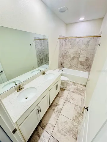 a spacious bathroom with a tub sink and mirror