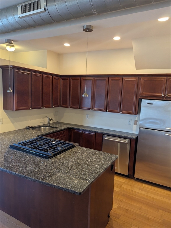 176 Hillside Street, Unit 101 Boston, MA 02120 - Photo 8 of 20 a kitchen with wooden cabinets and a granite counter top