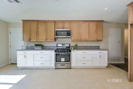 240 West Benson Avenue Ridgecrest, CA 93555 - Photo 3 of 29 a kitchen with granite countertop white cabinets and stainless steel appliances