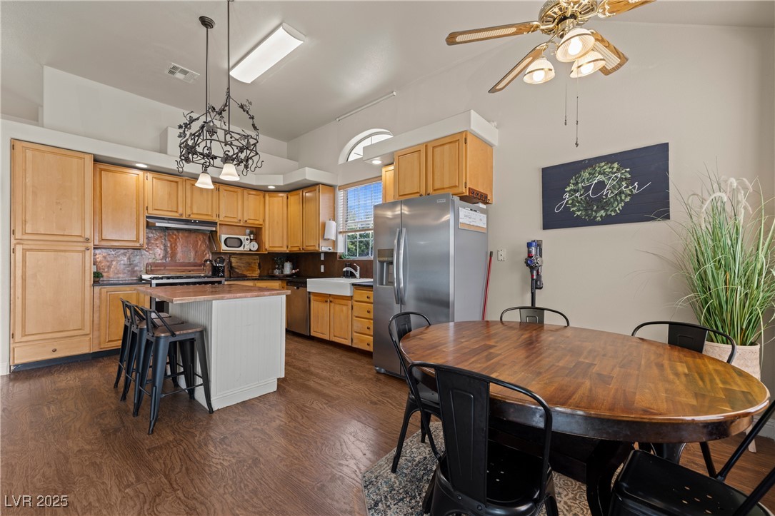 1951 Jim Haworth Court Logandale, NV 89021 - Photo 18 of 63 Kitchen with under cabinet range hood, a kitchen island, visible vents, appliances with stainless steel finishes, and dark wood-style floors