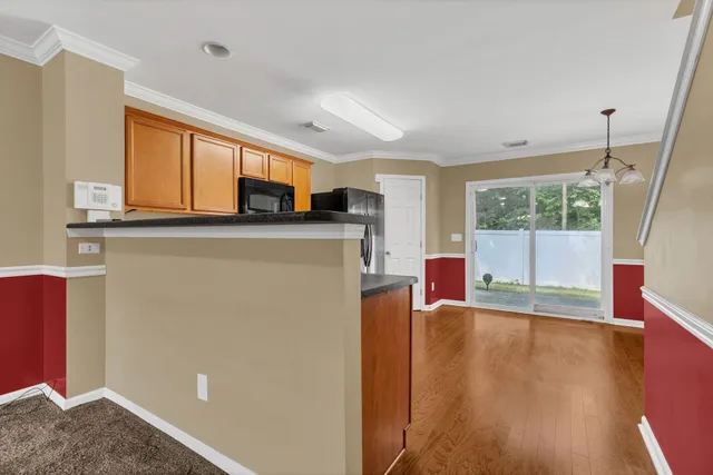 a living room with furniture a large window and wooden floor