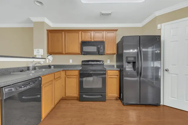 a kitchen with granite countertop a refrigerator and a sink