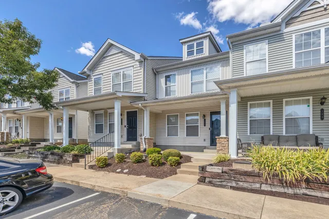 a view of a brick house with many windows and potted plants