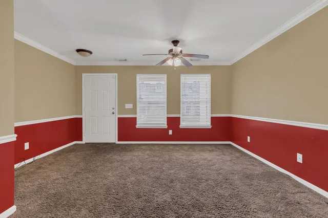 an empty room with windows and ceiling fan