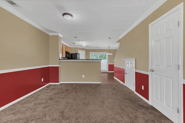 an empty room with kitchen and window