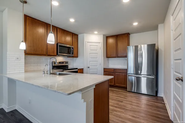 a kitchen with stainless steel appliances granite countertop a refrigerator and a stove top oven