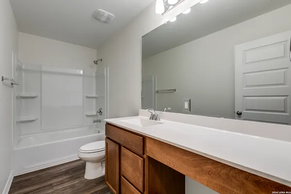 a bathroom with a sink toilet vanity and shower