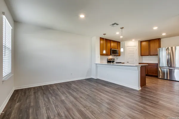 a view of kitchen with refrigerator microwave and wooden floor