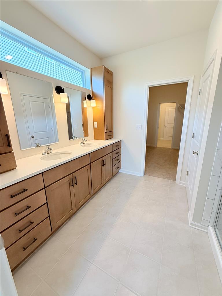 328 Abby Road, Unit LOT 15 Macungie, PA 18062 - Photo 18 of 26 Double vanity, broad window, and tiled flooring create a bright, inviting bathroom.