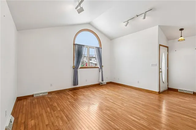 a view of empty room with wooden floor