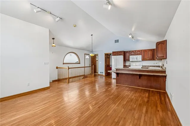 a room with wooden floor and view kitchen