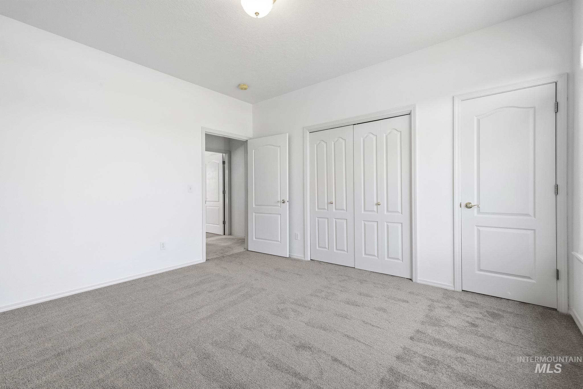 15181 Drury Way Caldwell, ID 83607 - Photo 30 of 49 Spacious room featuring light gray carpet, crisp white walls, white trim, and white paneled doors