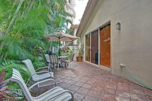 5156 Northwest 26th Circle Boca Raton, FL 33496 - Photo 14 of 18 a view of a patio with a table and chairs under an umbrella