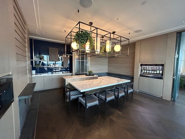 a dining room with wooden floor a chandelier a wooden table and chairs