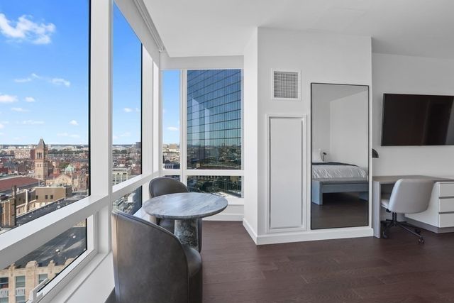 a bathroom with a tub a sink and a large window