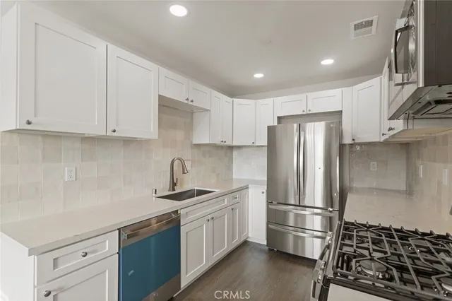 a kitchen with a refrigerator sink and cabinets