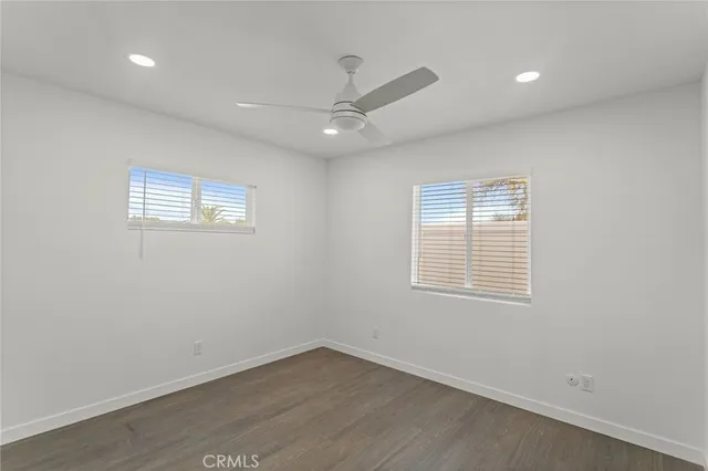an empty room with a window and ceiling fan