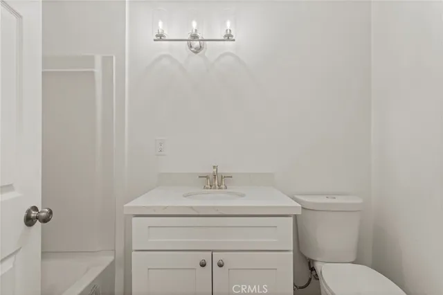 a bathroom with a sink toilet and a mirror